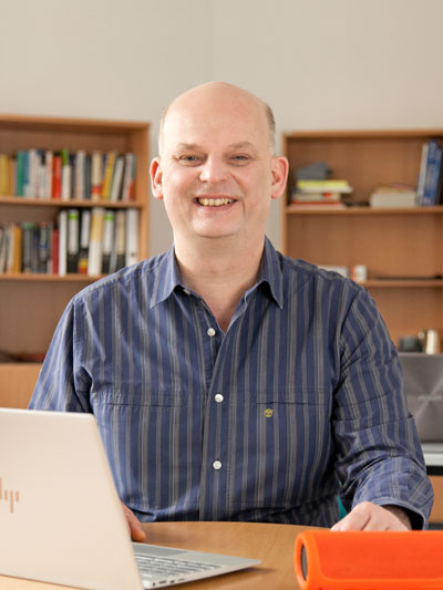 Portraitfoto: Jan Hellbusch in einem gestreiften Hemd